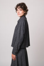 Model trägt eine graue Blazerjacke und eine türkisblaue Bluse der Marke Luisa Cerano.
