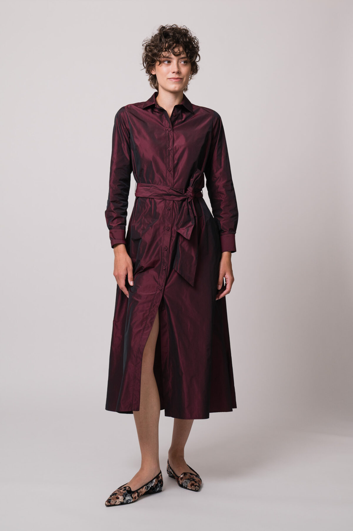 Model trägt ein weinrotes Kleid der Marke Rosso35.