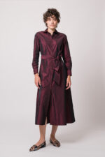 Model trägt ein weinrotes Kleid der Marke Rosso35.