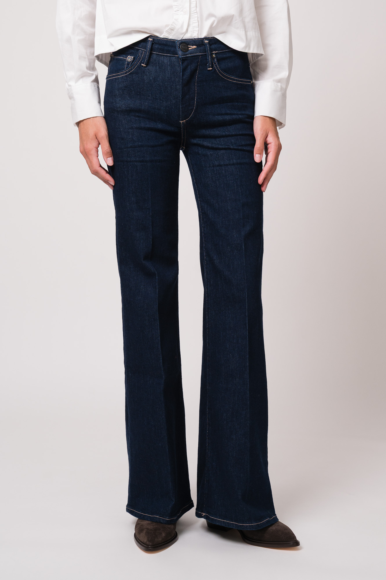 Model trägt eine Jeans der Marke True Religion.