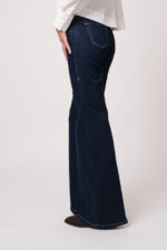 Model trägt eine Jeans der Marke True Religion.