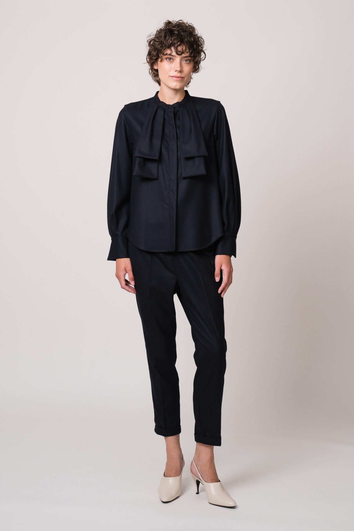 Model trägt eine dunkelblaue Bluse und Hose der Marke Lis Lareida.