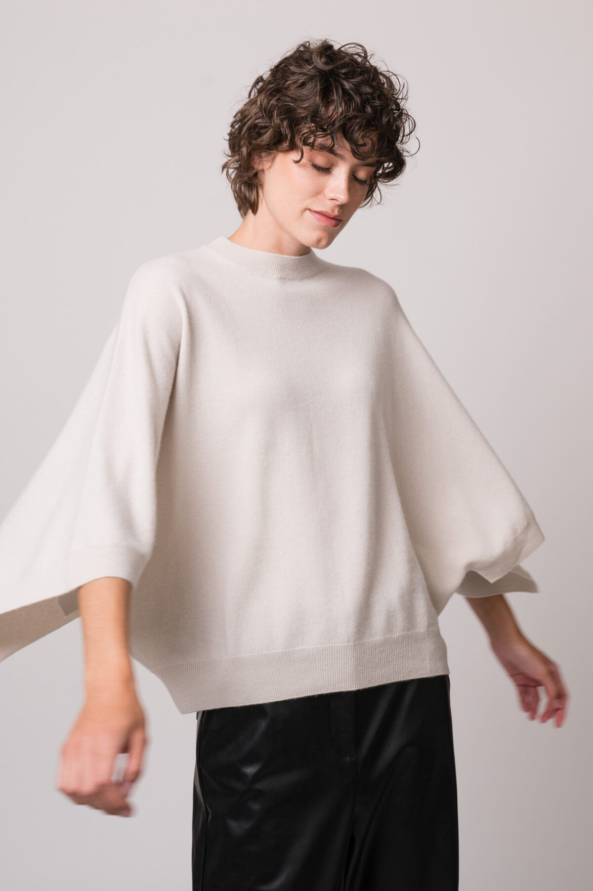 Model trägt einen beigen Pullover der Marke Herzens