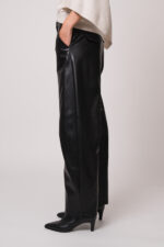 Model trägt eine schwarze Hose der Marke Cambio.