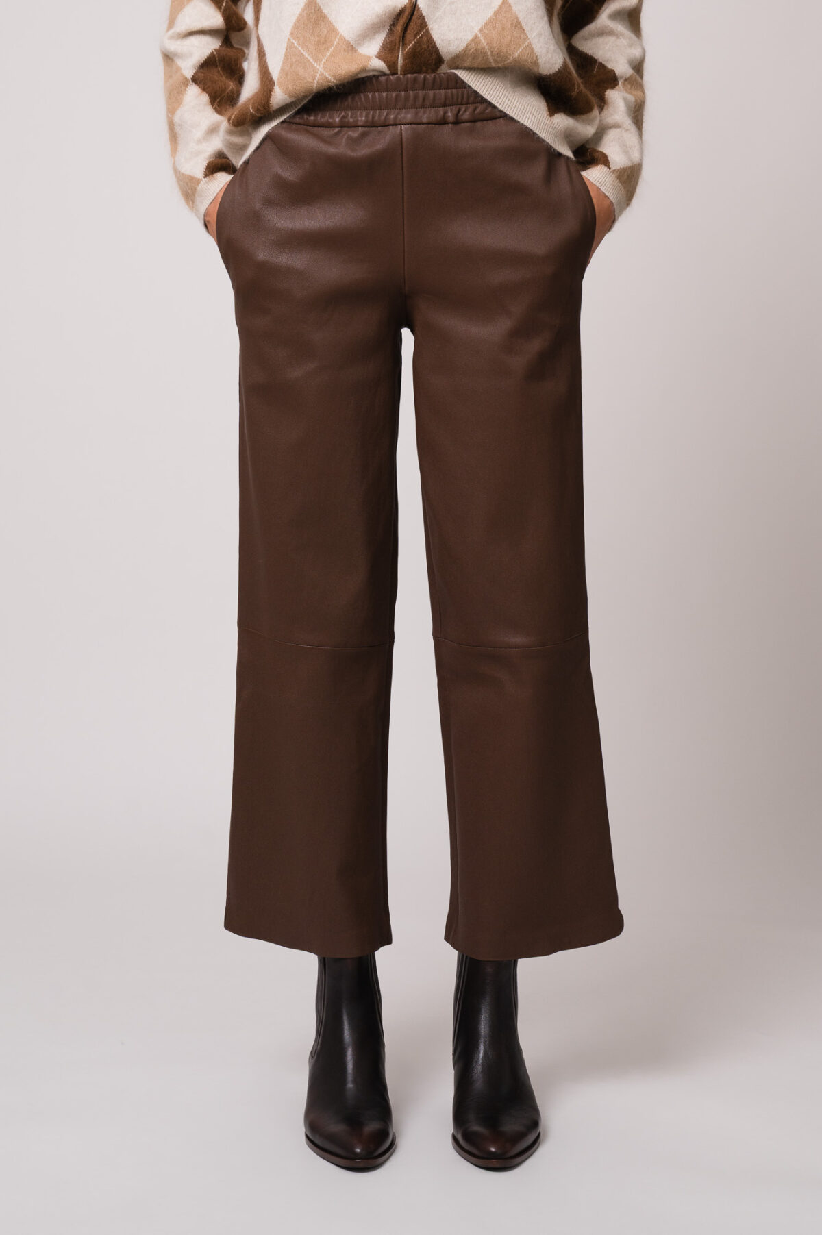 Model trägt eine braune Lederhose der Marke Hemisphere.