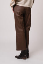 Model trägt eine braune Lederhose der Marke Hemisphere.