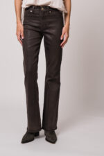 Model trägt eine braune Jeans der Marke 7 for all mankind.