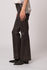 Model trägt eine braune Jeans der Marke 7 for all mankind.