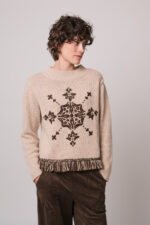 Model trägt einen braun gemusterten Pullover der Marke Grace und eine braune Hose der Marke Cambio.