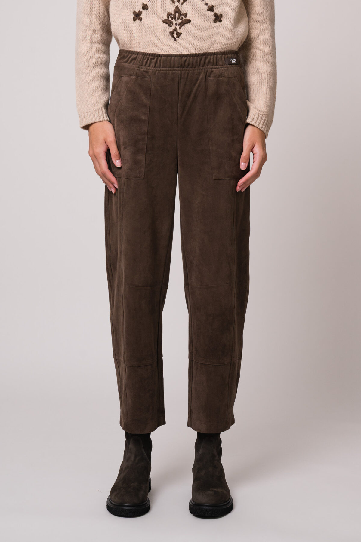 Model trägt eine braune Hose der Marke Cambio.