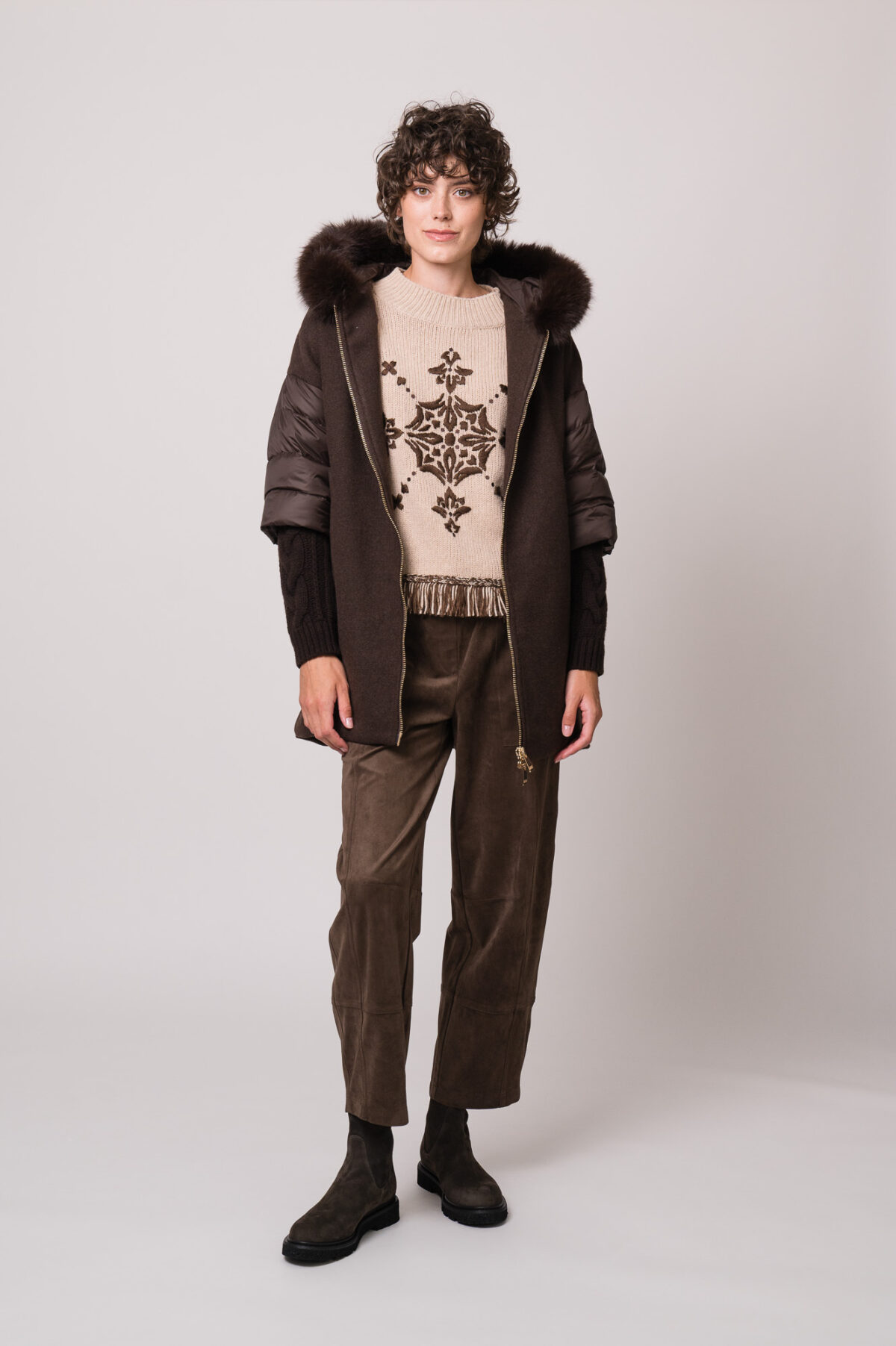 Model trägt eine braune Jacke der Marke Marco dele Forte, einen braun gemusterten Pullover der Marke Grace und eine braune Hose der Marke Cambio.