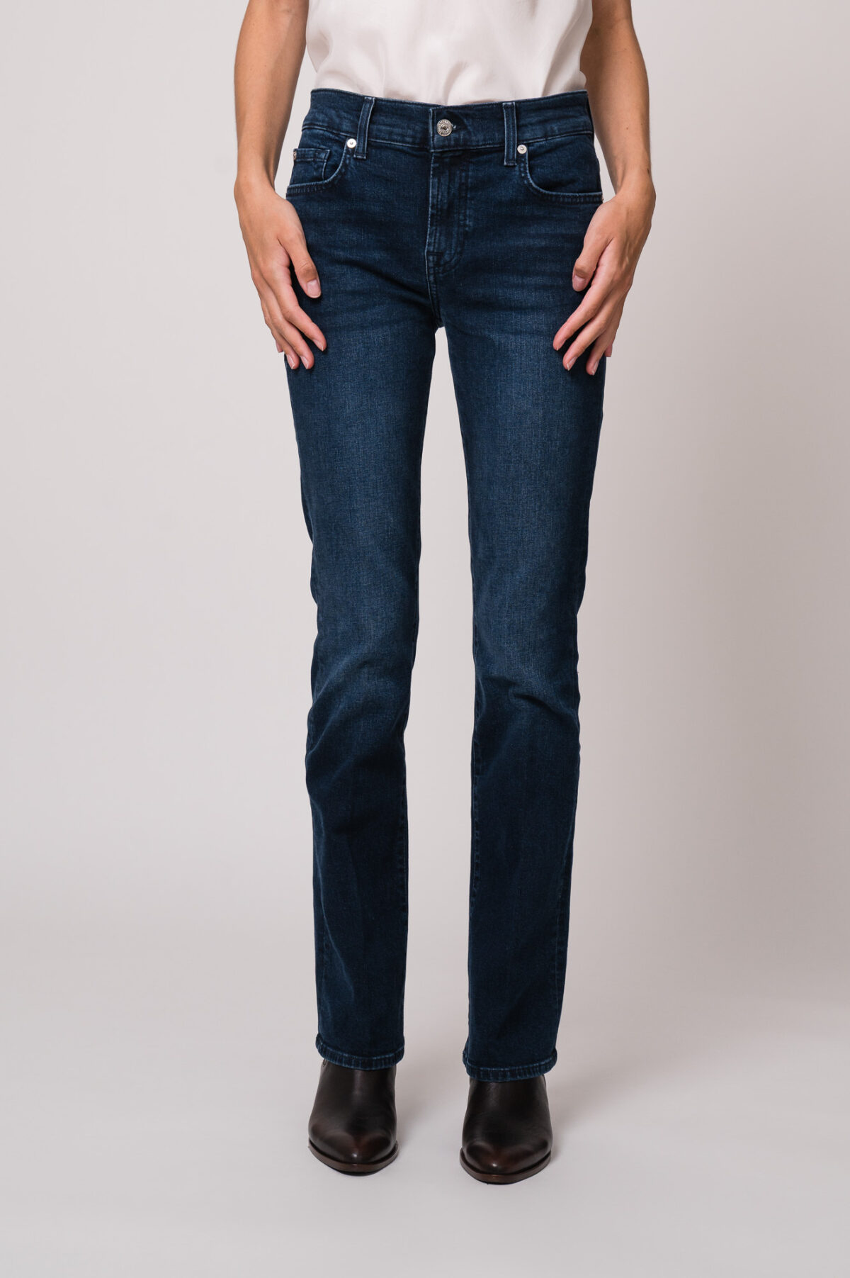 Model trägt eine blaue Jeans der Marke 7 for all mankind.