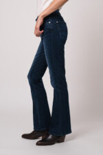 Model trägt eine blaue Jeans der Marke 7 for all mankind.