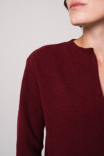 Model trägt ein weinrotes Strickkleid der Marke Rosso35