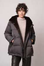 Model trägt eine dunkle Jacke der Marke Lou Andrea, einen natur-farbigen Pullover der Marke FFC und eine braune Hose der Marke Lis Lareida.