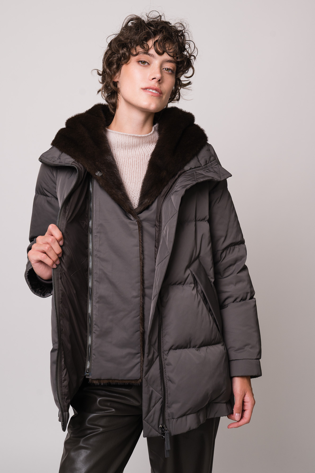 Model trägt eine dunkle Jacke der Marke Lou Andrea, einen natur-farbigen Pullover der Marke FFC