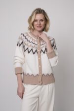 Das Model trägt eine gemusterte Strickweste von Sosue und eine Hose von Cambio in Natur.