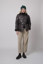 Das Model trägt einen braunen Rollkragenpullover von FFC und eine sandfarbene Cordhose von Joop. Die braune Daunenjacke stammt von Helmur.
