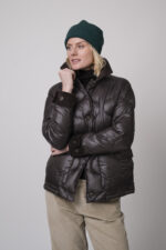 Das Model trägt einen braunen Rollkragenpullover von FFC und eine sandfarbene Cordhose von Joop. Die braune Daunenjacke stammt von Helmur.