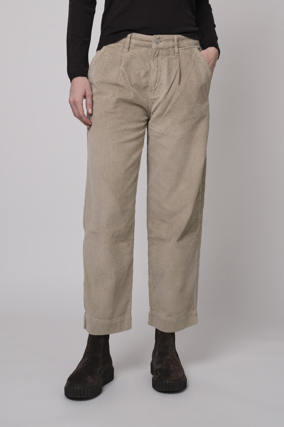 Das Model trägt einen Rollkragenpullover in Bordeaux von FFC und eine Cordhose von Joop in Sand.