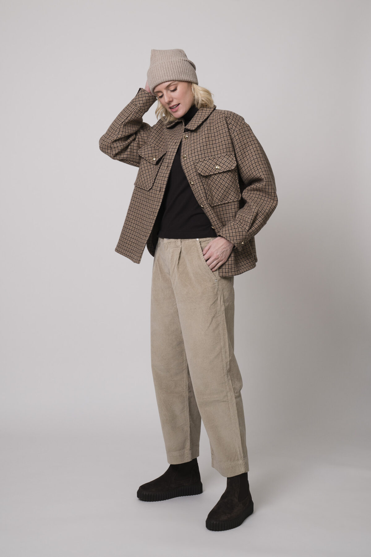 Das Model trägt eine karierte Jacke von Sosue in Camel und eine Cordhose von Joop in Sand.