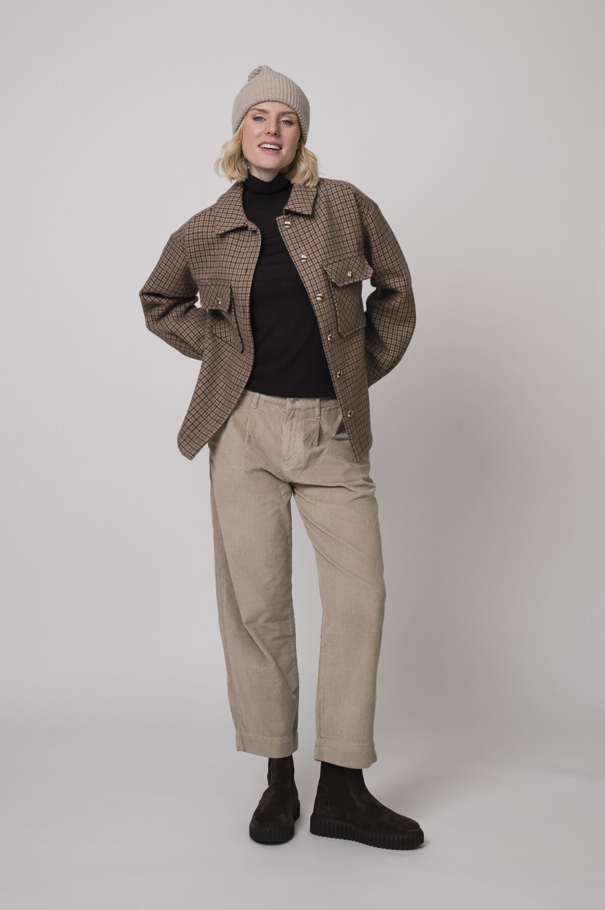 Das Model trägt eine karierte Jacke von Sosue in Camel und eine Cordhose von Joop in Sand.