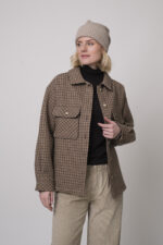 Das Model trägt eine karierte Jacke von Sosue in Camel und eine Cordhose von Joop in Sand.