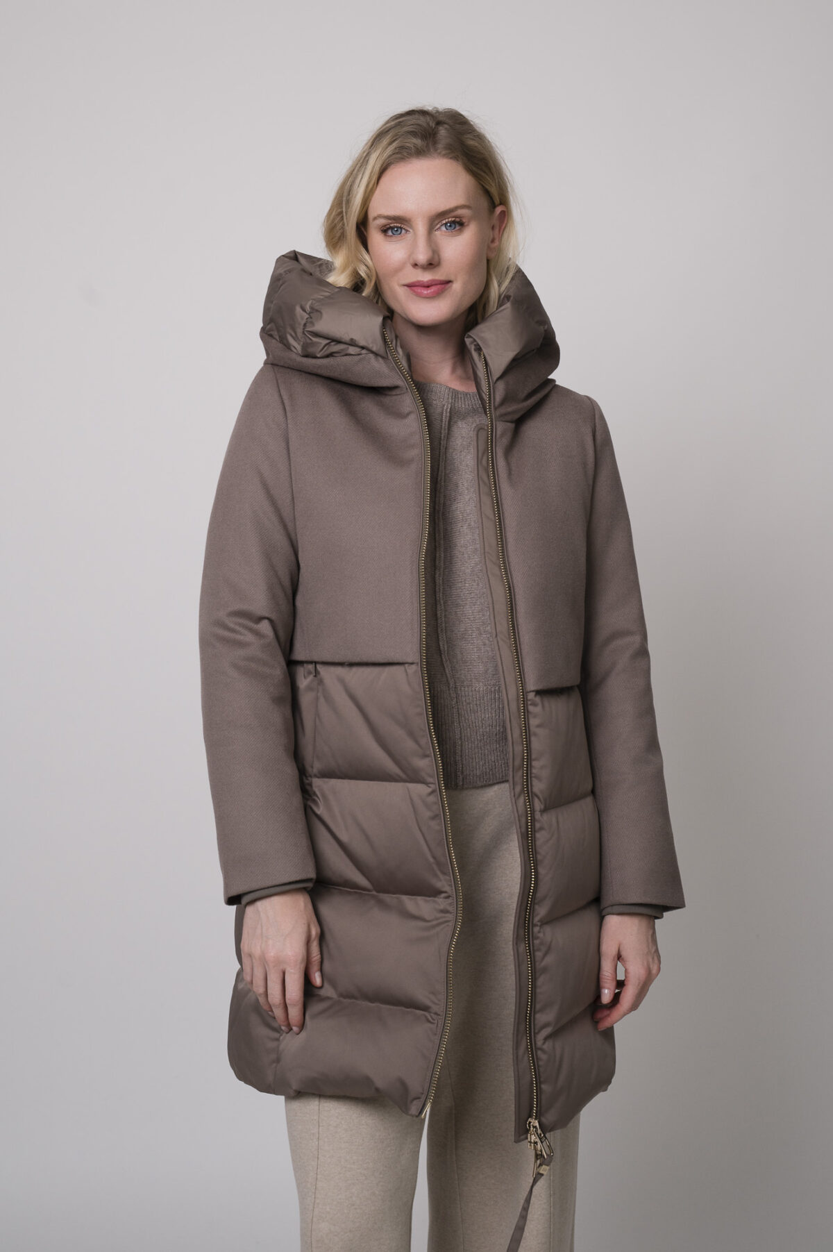 Das Model trägt eine Hose der Marke Cambio in Sand, einen braunen Pullover der Marke Sosue und eine braune Jacke der Marke Duno.