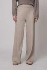 Das Model trägt eine Hose der Marke Cambio in Sand und einen braunen Pullover der Marke Sosue.