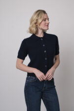 Das Model trägt eine Jeans von 7 for all mankind und eine Strickweste von True Religion in Marine.