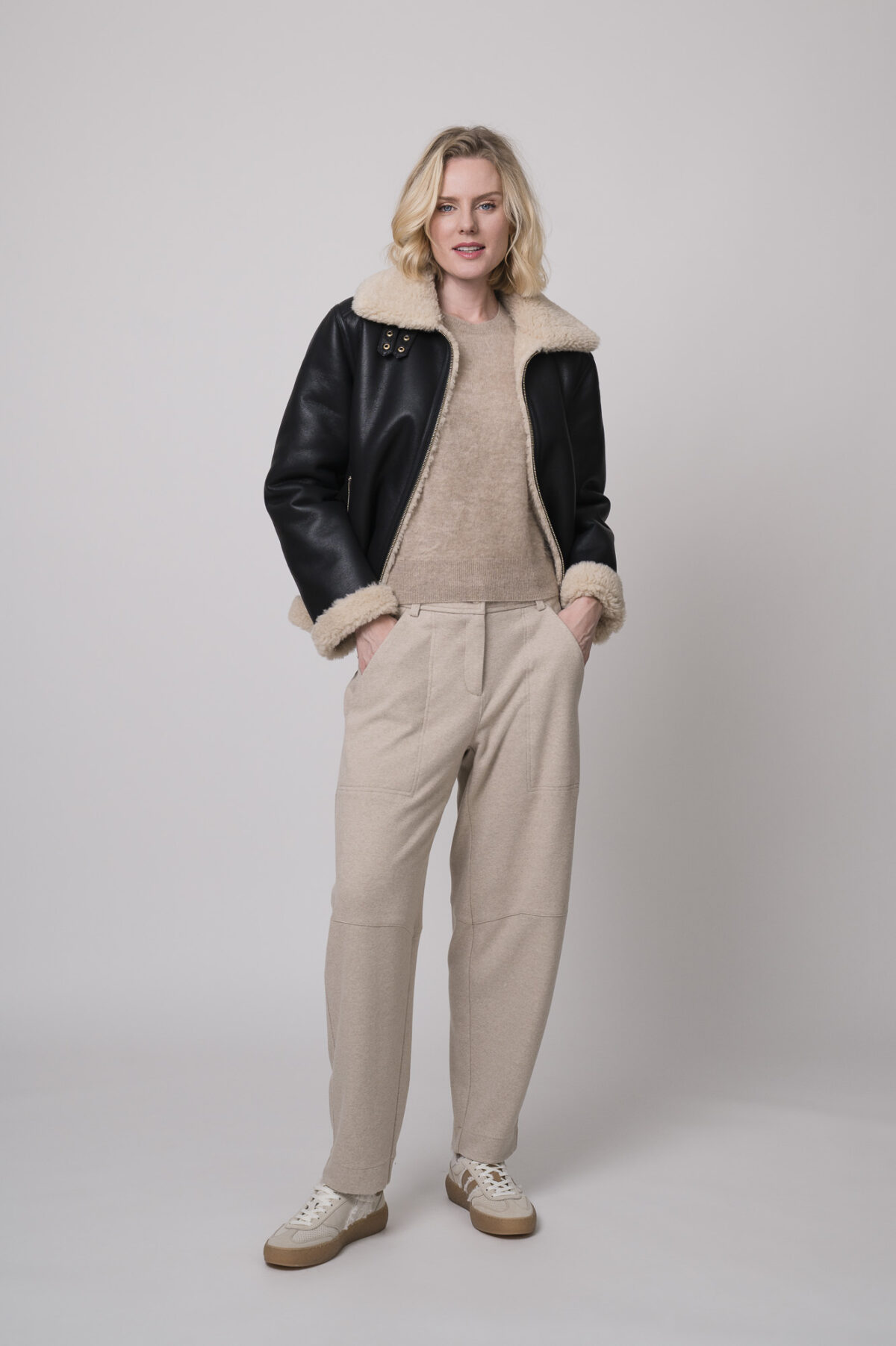 Das Model trägt eine schwarze Jacke von Joop, eine sportliche Hose von Cambio in Sand sowie einen Camel-Pullover von Absolut Cashmere.