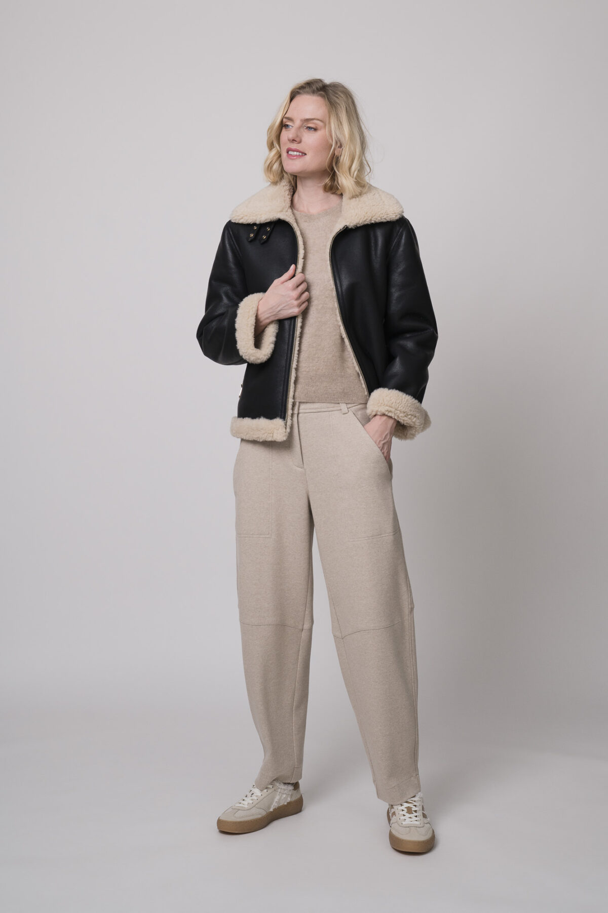 Das Model trägt eine schwarze Jacke von Joop, eine sportliche Hose von Cambio in Sand sowie einen Camel-Pullover von Absolut Cashmere.