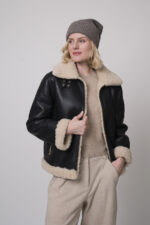 Das Model trägt eine schwarze Jacke von Joop, eine Haube von FFC sowie eine sportliche Hose von Cambio in Sand, und einen Camel-Pullover von Absolut Cashmere.