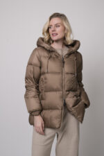 Das Model trägt eine camelfarbene Daunenjacke von Mabrun, eine sandfarbene Hose von Cambio und einen Camel-Pullover von Absolut Cashmere.