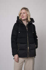 Das Model trägt eine schwarze Daunenjacke von Duno, eine sandfarbene Hose von Cambio und einen Pullover von Absolut Cashmere in Camel.