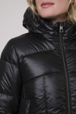 Das Model trägt eine Daunenjacke der Marke Helmur in mittelblau.