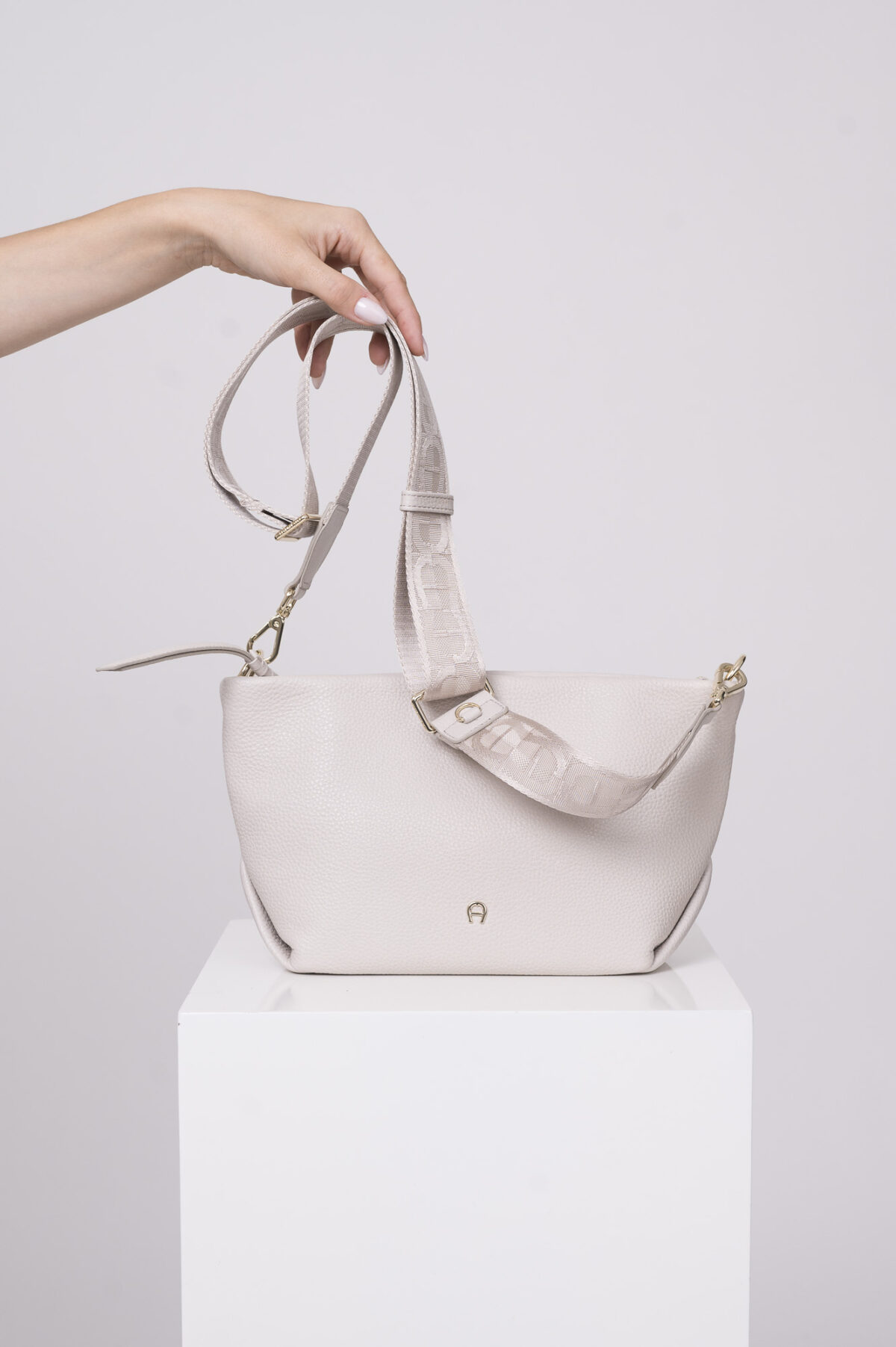 Produktaufnahme einer natur farbige Tasche der Marke Aigner