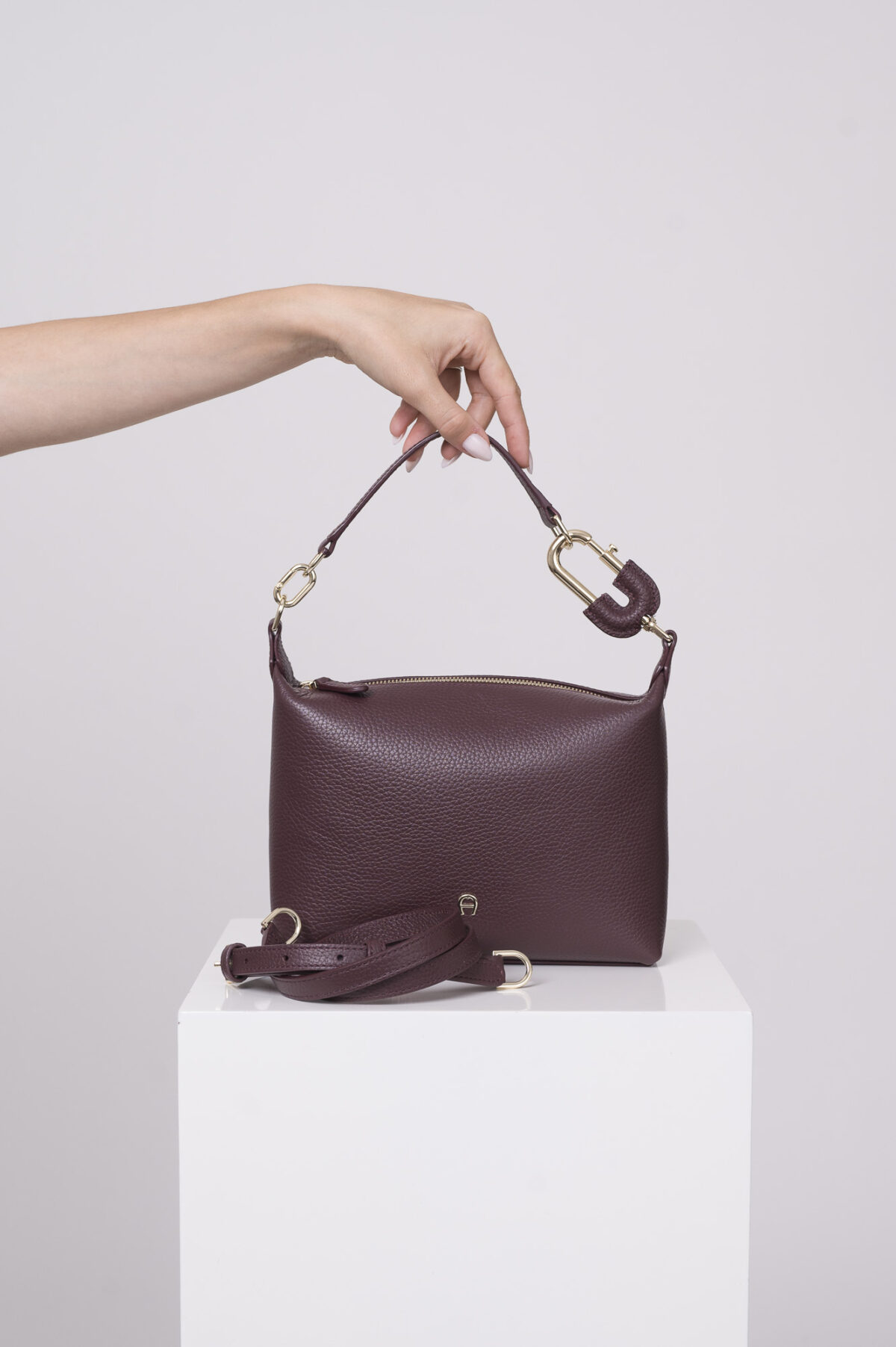 Produktaufnahme einer weinrote Tasche der Marke Aigner