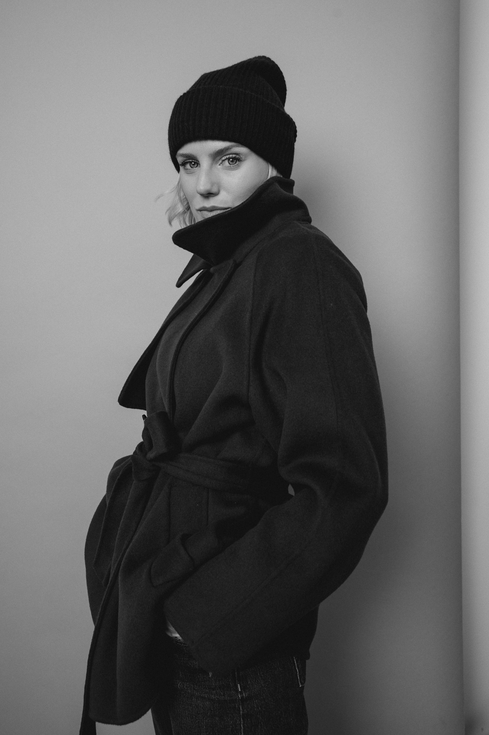 Model trägt einen blauen Mantel der Marke Helmur. Bild in schwarz-weiß