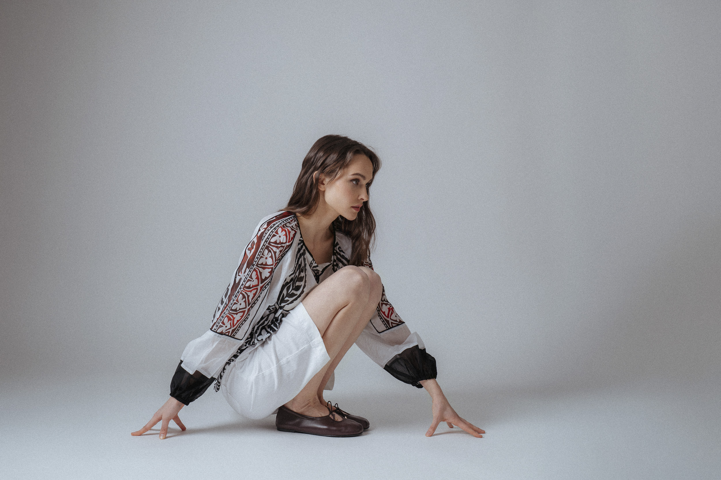 Model zeigt eine weiße Bermudas der Marke Luisa Cerano und eine bunte Bluse der Marke Devotion.