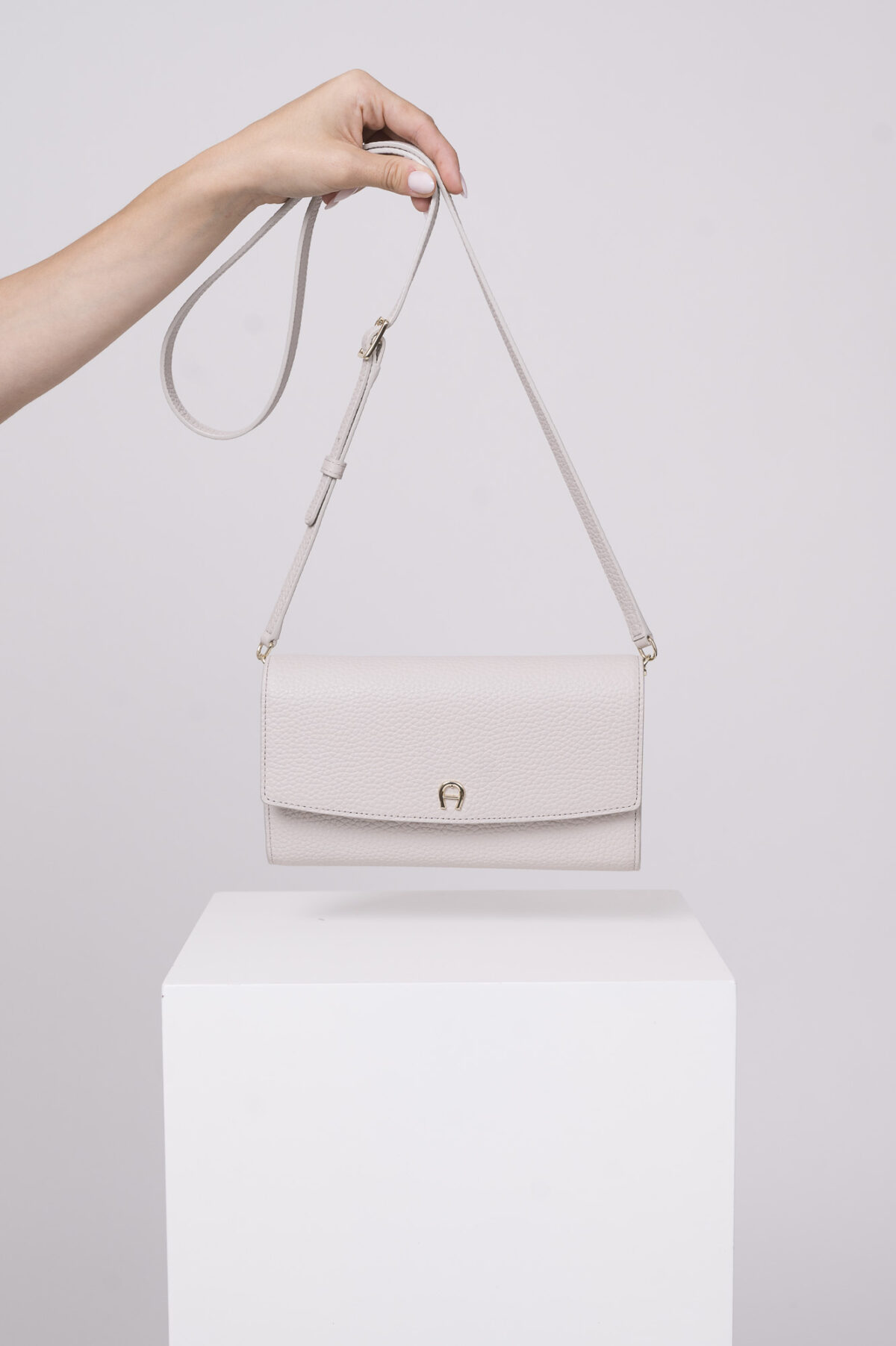 Produktaufnahme einer natur farbigen Tasche der Marke Aigner