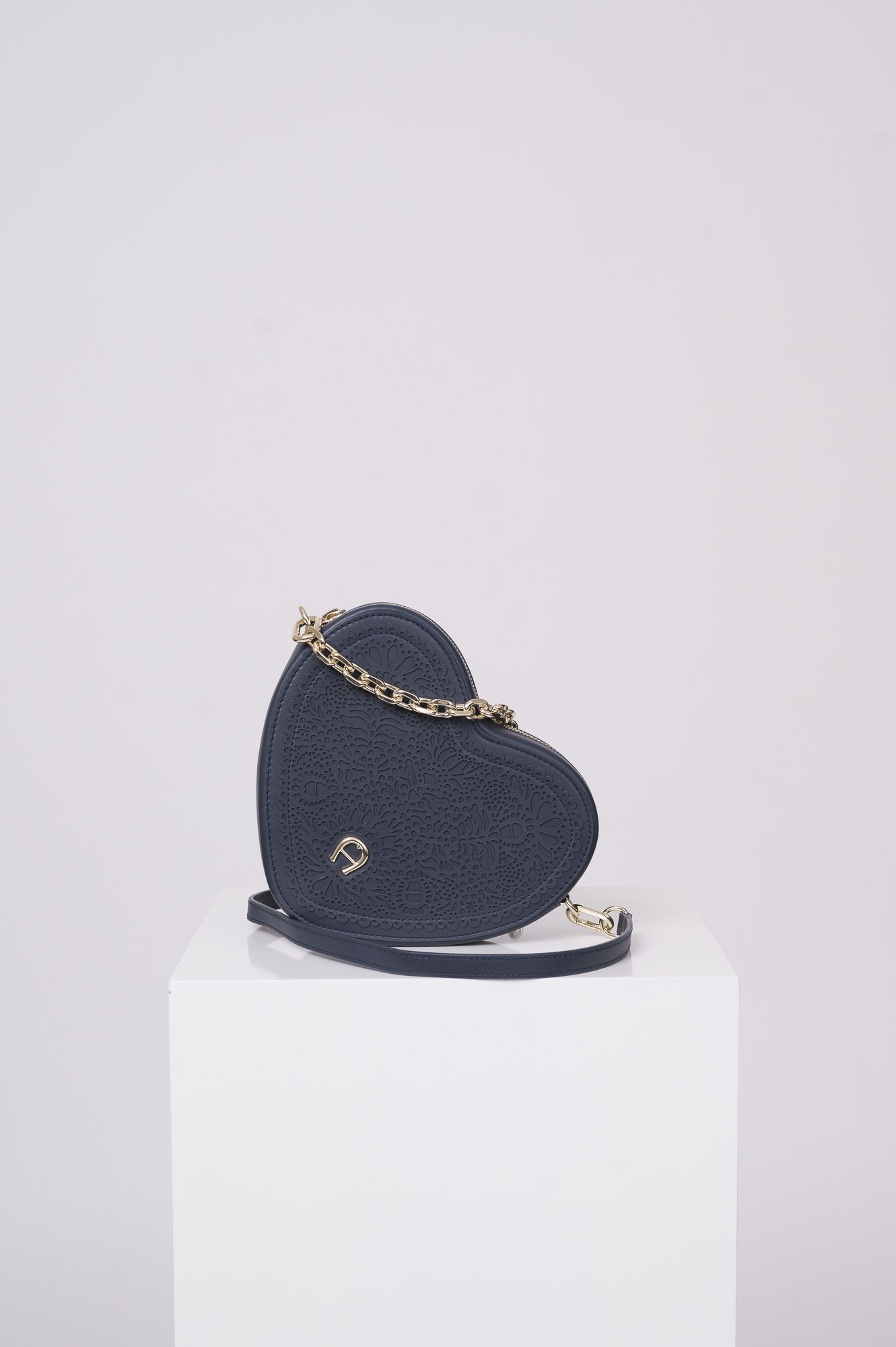 Produktaufnahme einer marine blauen Tasche in Herzform der Marke Aigner