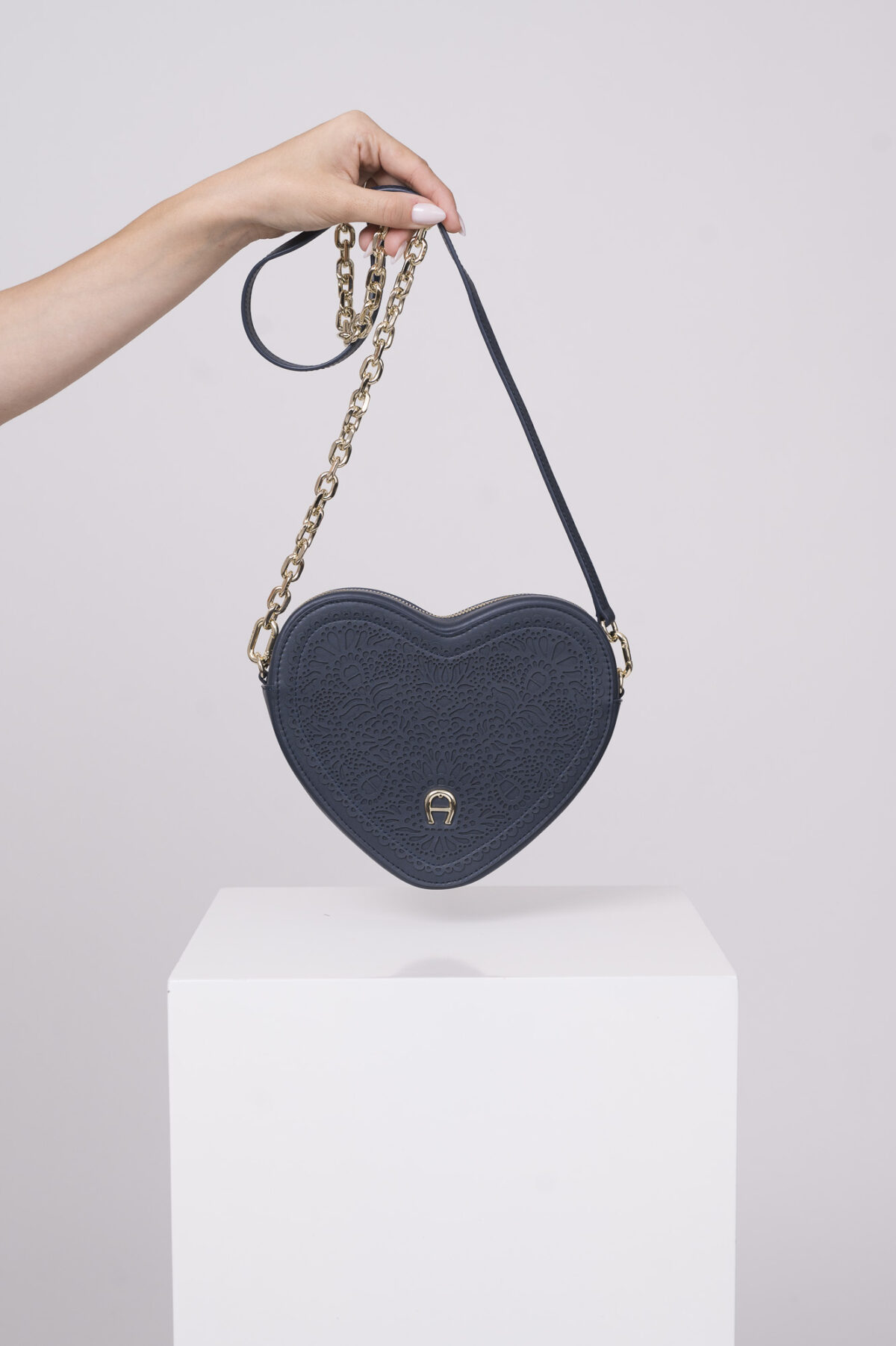 Produktaufnahme einer marine blauen Tasche in Herzform der Marke Aigner