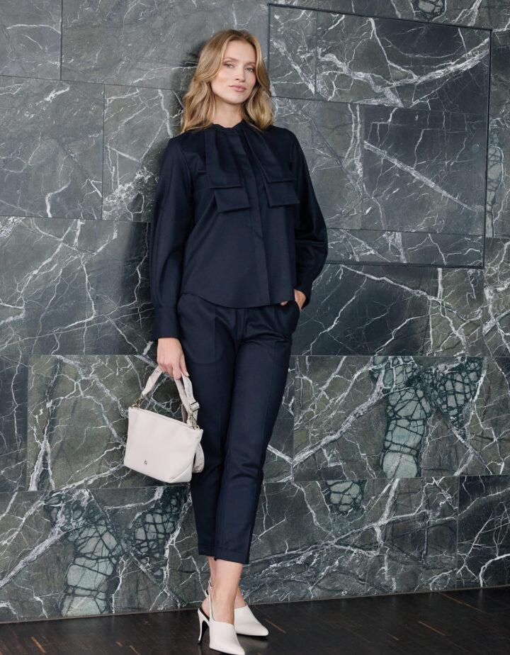Model trägt eine marine-blaue Bluse und Hose der Marke Lis Lareida
