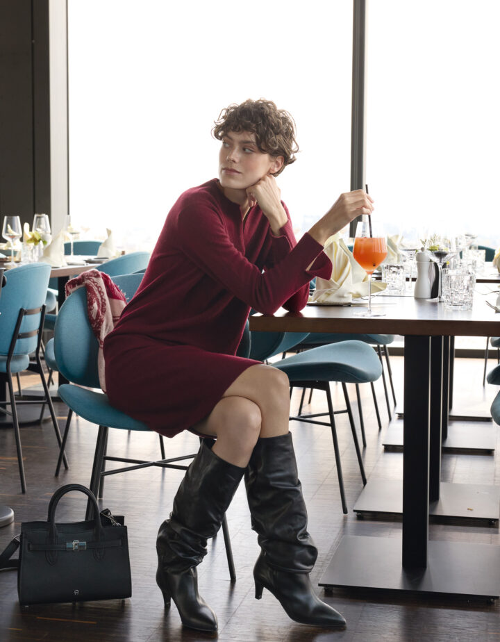 Model trägt ein weinrotes Strickkleid der Marke Rosso35