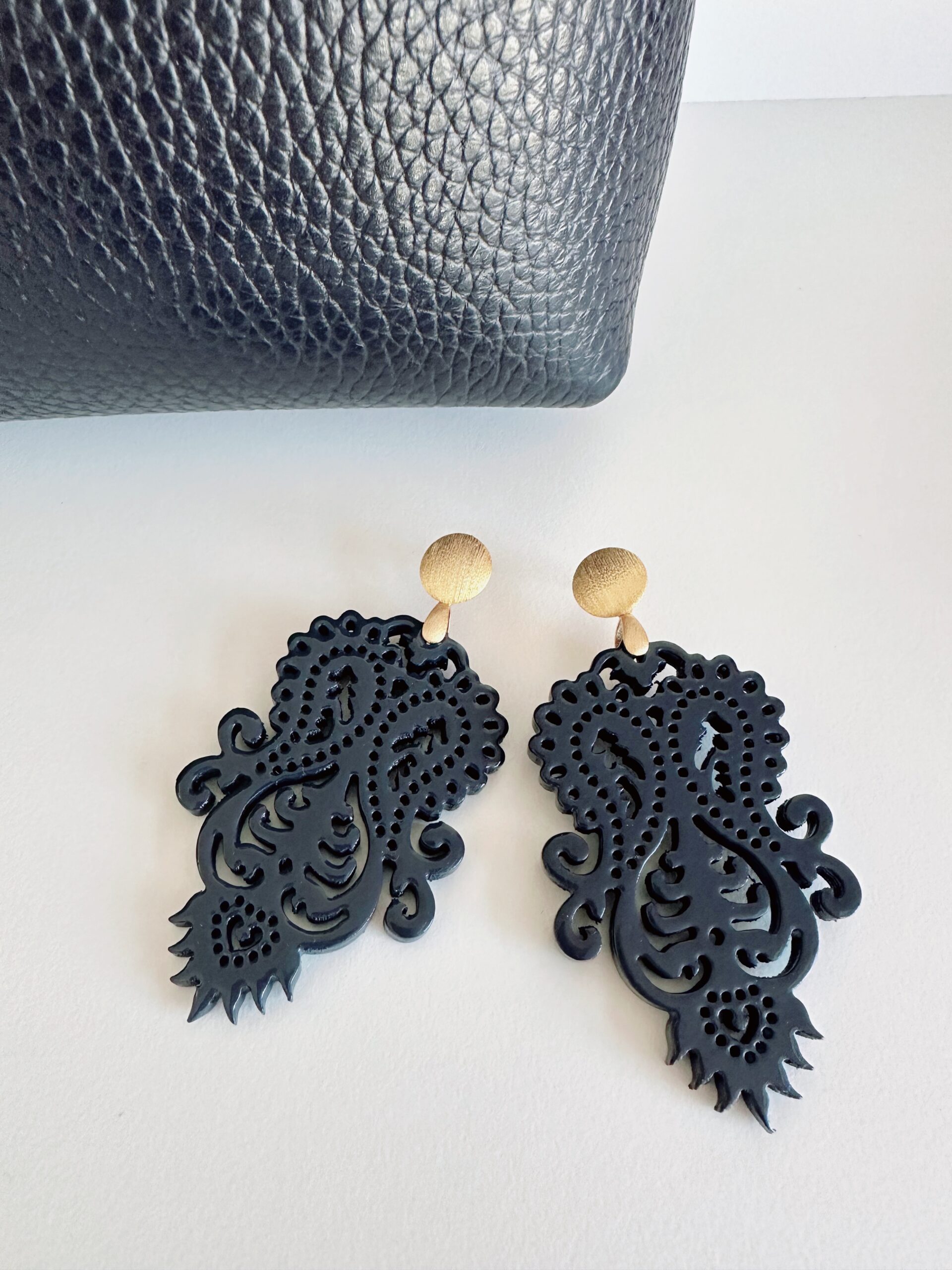 Dunkelblauer Ohrring und kleine Tasche des Schmucklabels Ohrangerie