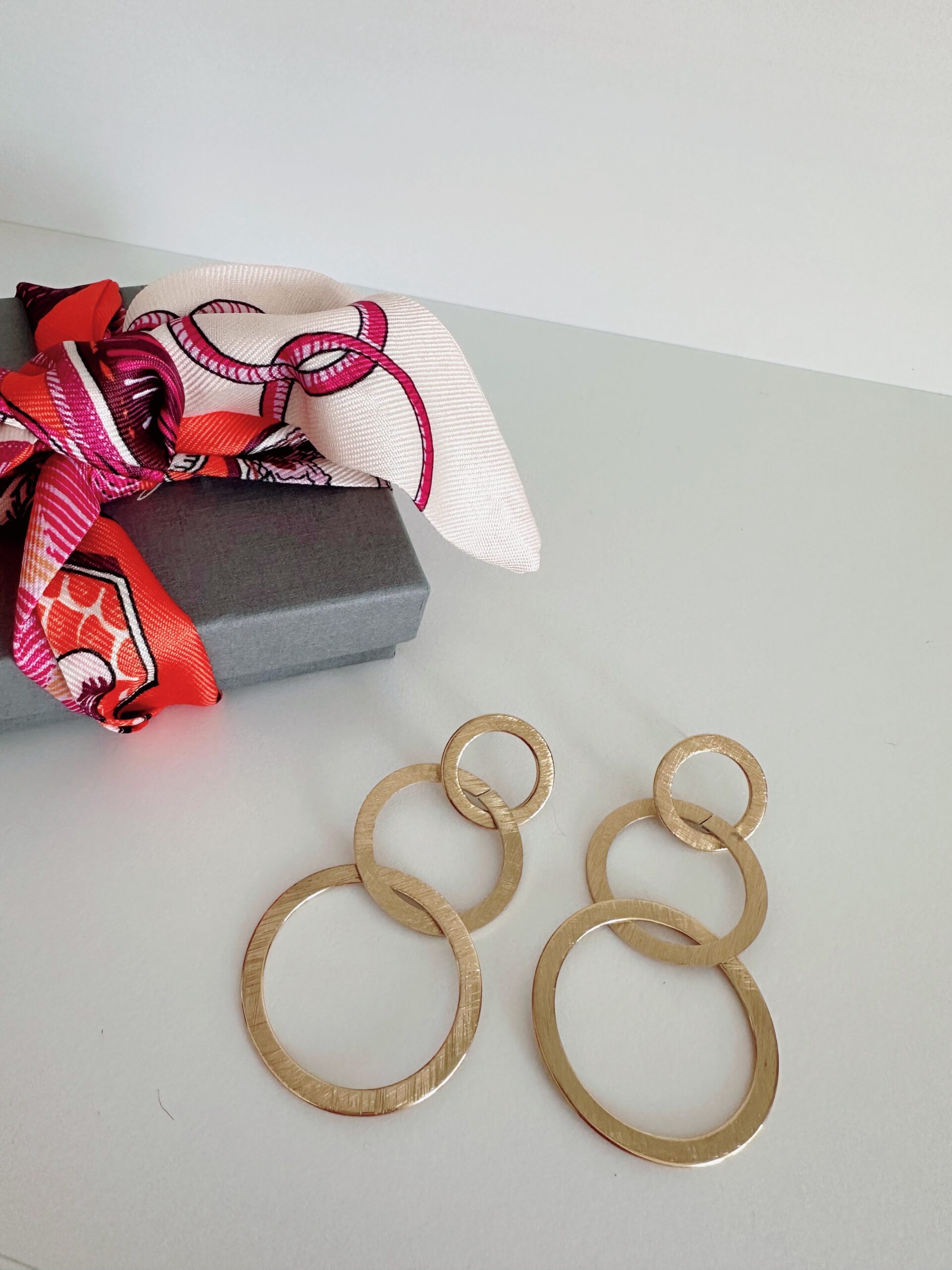 Goldener Ohrring des Schmucklabels Ohrangerie samt Tuch